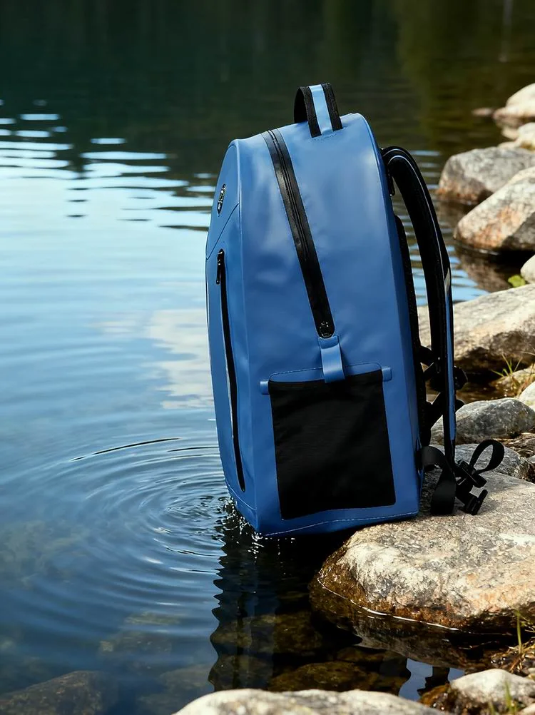 Blue dry bag backpack beside the water
